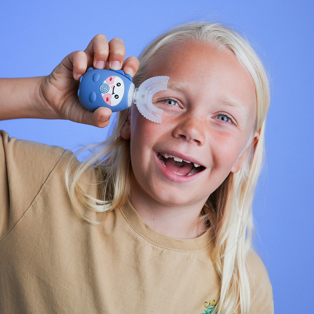 Child holding a blue eye care device against their eye with a blue background